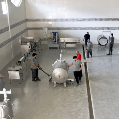 Team positioning canning equipment inside a production hall